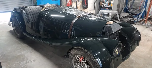 Restored Morgan front quarter showing curved wings, deep green paintwork and wire wheels