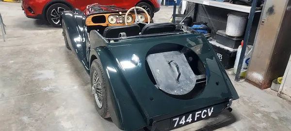 Restored classic Morgan sports car rear view with completed dark green paintwork